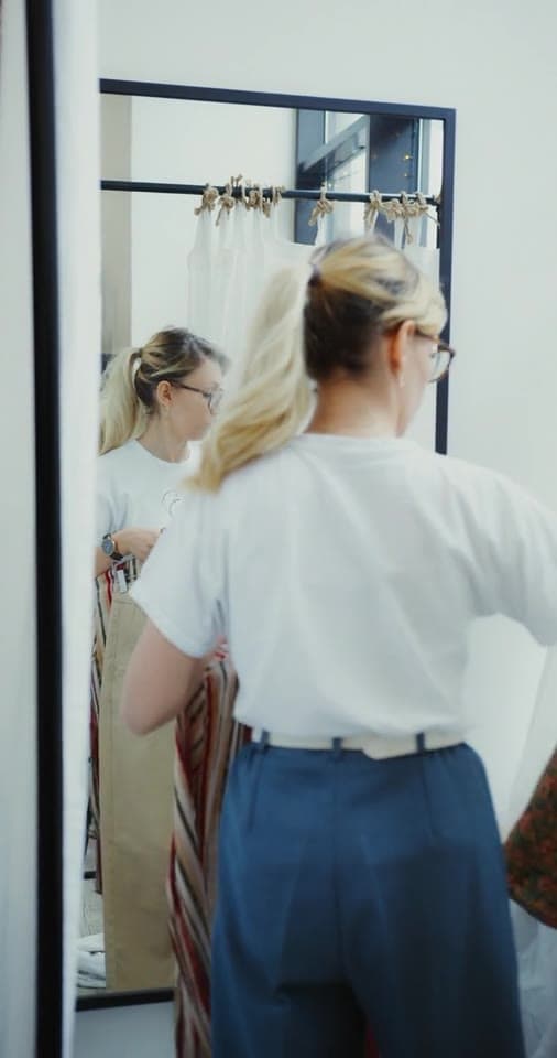 Example clip 1 of 3, from 0:04: a creator holding up khaki trousers in a mirror