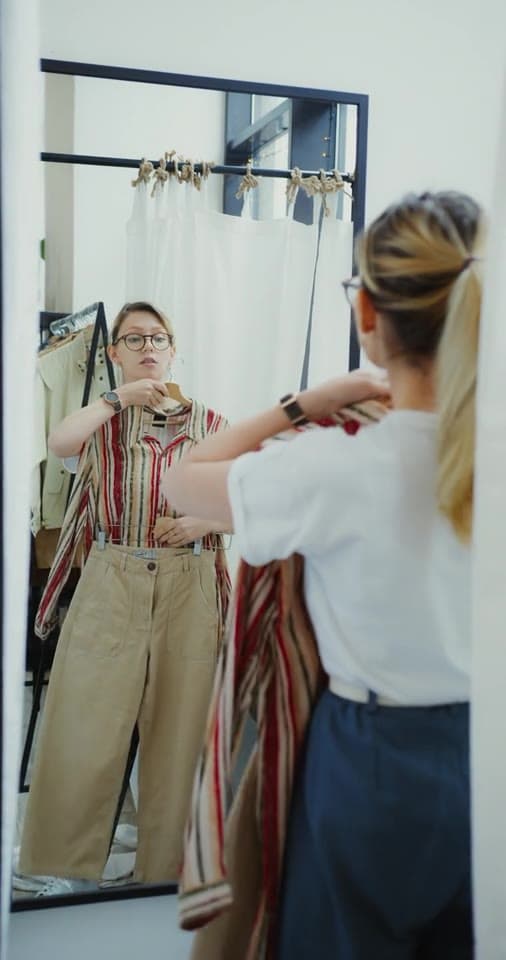 Example clip 2 of 3, from 1:12: a creator trying on a striped top in a mirror